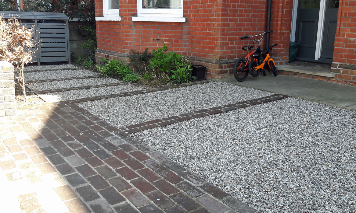 Lines of pavers and gravel extend into parking area